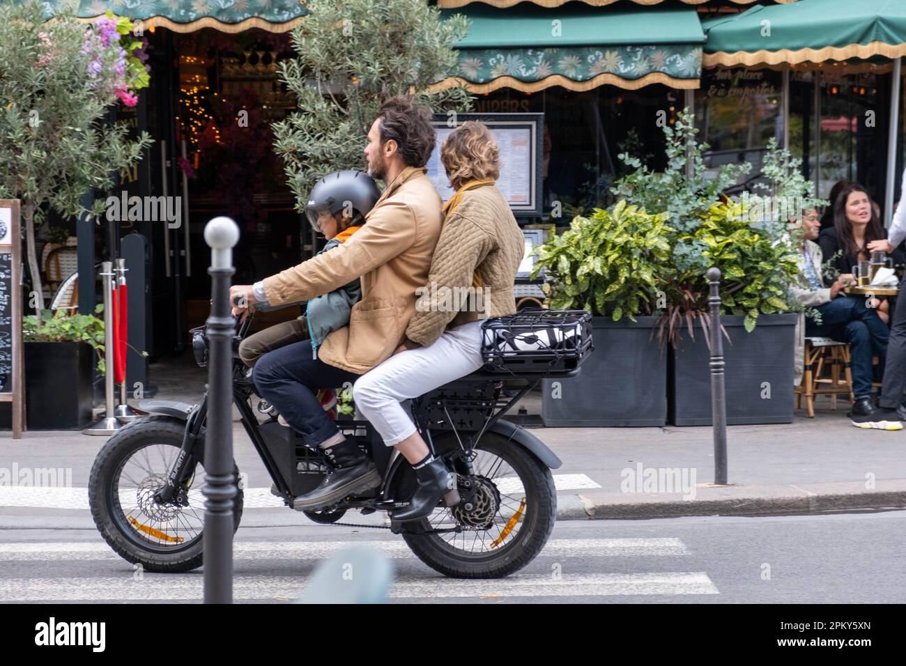 Vater, Mutter und Sohn fahren auf einem alten Motorrad durch die Straßen von Paris Stockfoto