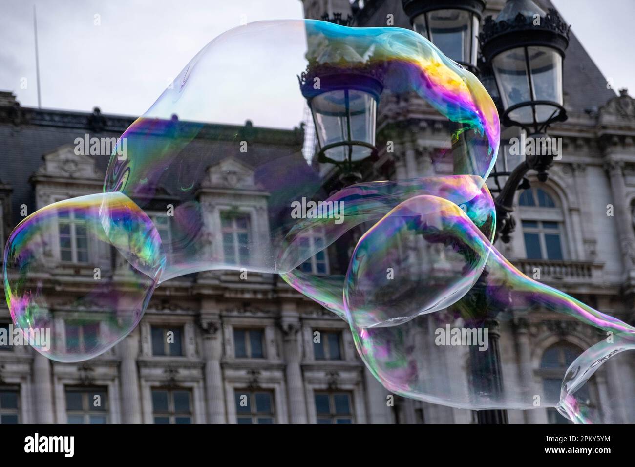 Riesige Seifenblase mit Lichtmast und altem Gebäude im Hintergrund Stockfoto