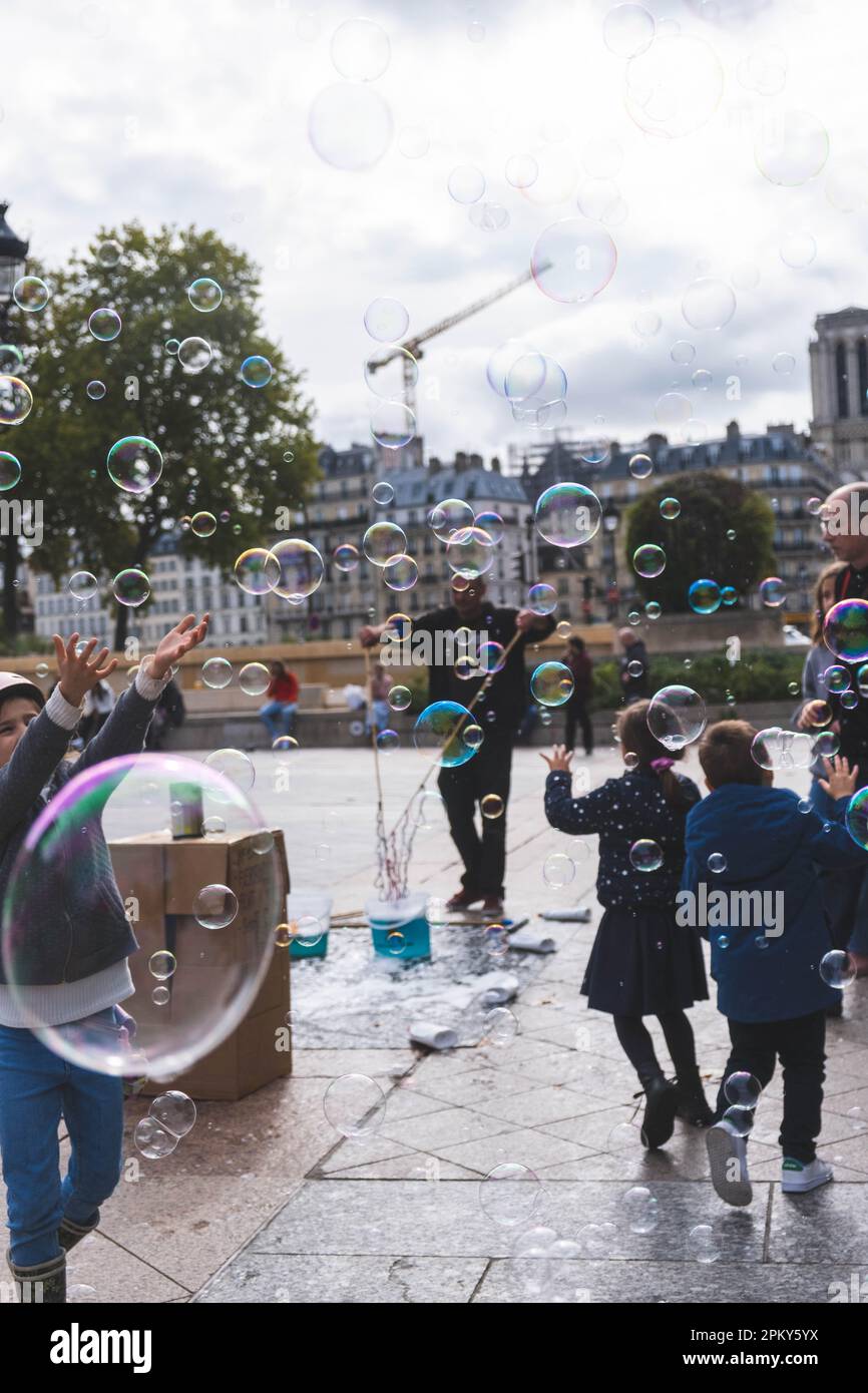 Fröhliche Momente: Kinder genießen eine Seifenblasenparty in Paris Stockfoto