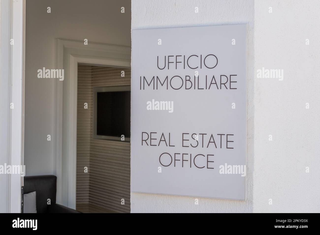 Ein italienisches Schild für Immobilienbüros an einer weißen Wand. Stockfoto