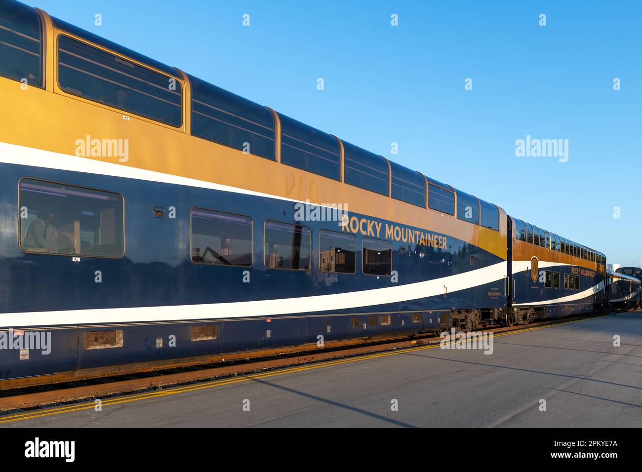 Goldfarbener Rocky Mountaineer Zugwaggon bei Sonnenaufgang in Vancouver Station. Stockfoto