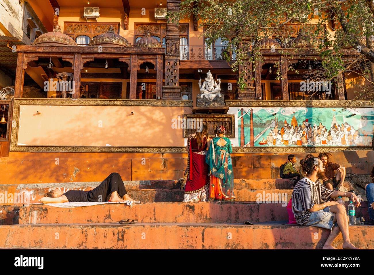 RISHIKESH, INDIEN - 27.03.2023: Ein typischer Tag in Rishikesh. Traditionelle Gebäude im Stadtzentrum, Tempeldächer, entspannte Yoga-Leute, Prai Stockfoto