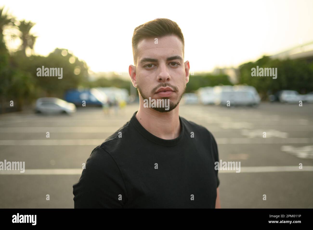Junger Mann, der auf dem Fußgängerüberweg steht Stockfoto