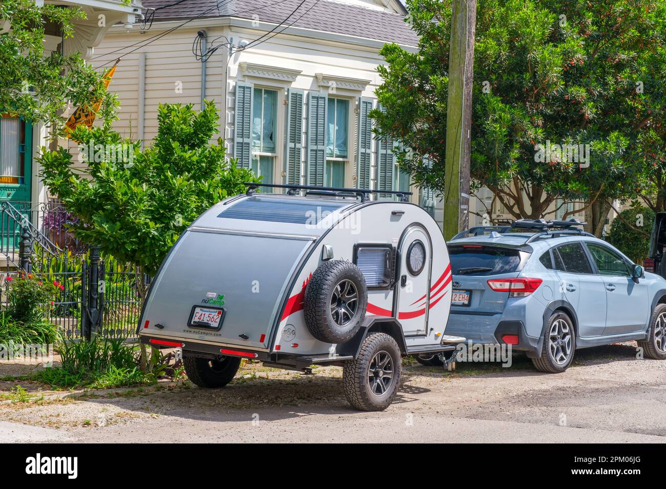 NEW ORLEANS, LA, USA - 4. APRIL 2023: Nucamp TAG Miniatur Wohnwagen Anhänger am geparkten Auto vor dem Wohnhaus in Uptown Stockfoto