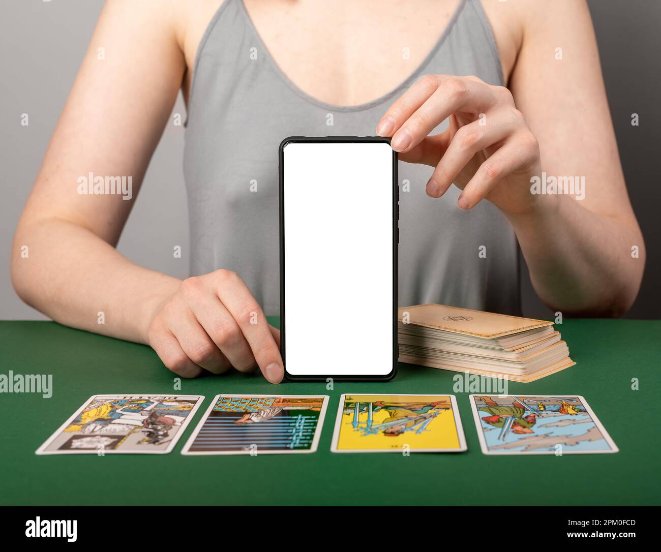 Lodz, Polen April 07 2023 Wahrsager mit Handymodell, Verteilen und Lesen von Tarotkarten. Cartomancy, Divination und Technologiekonzept. Stockfoto