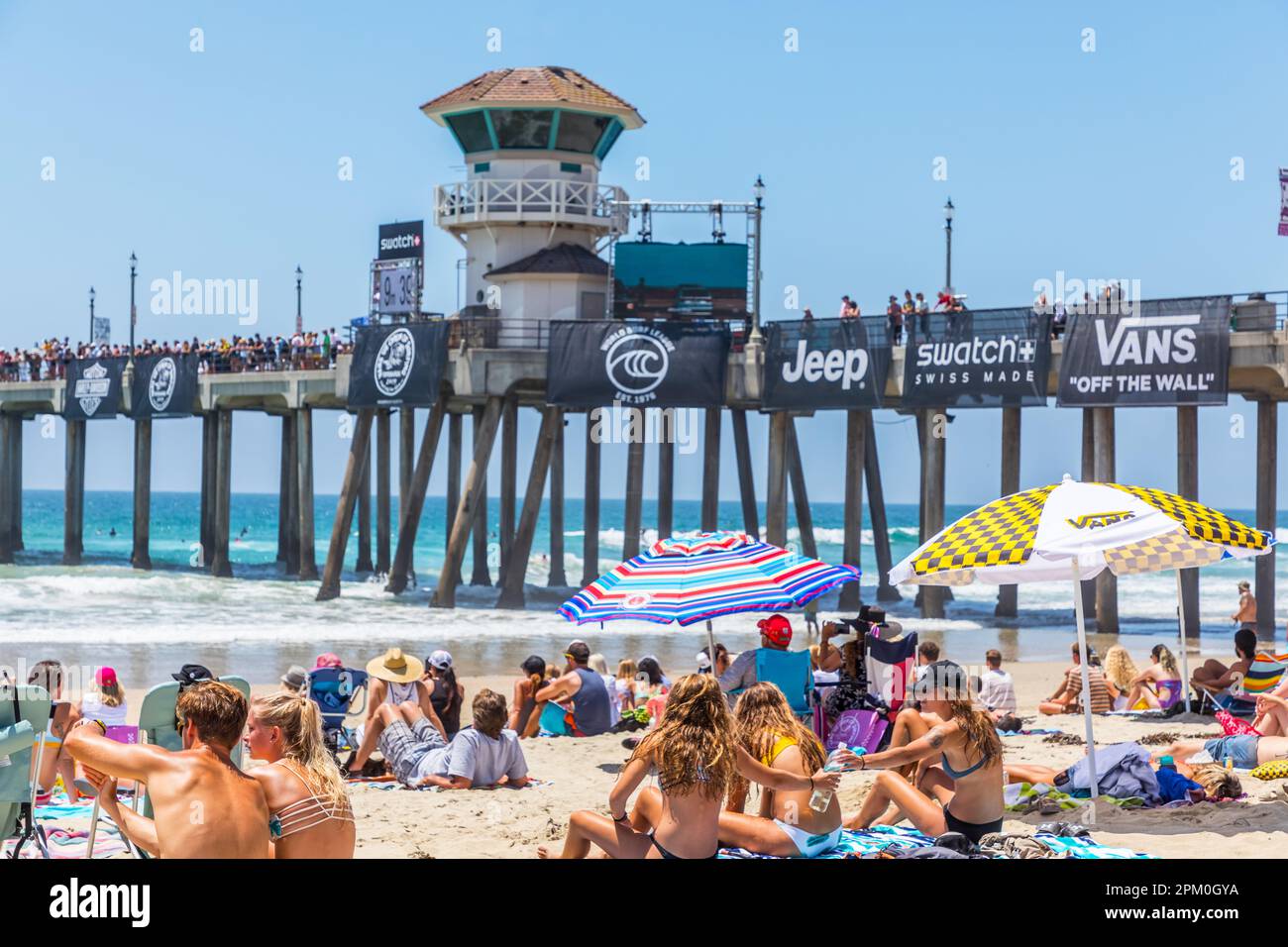 Leute, die am Strand während des Vans US Open of Surfing Competition in Huntington Beach sitzen Stockfoto