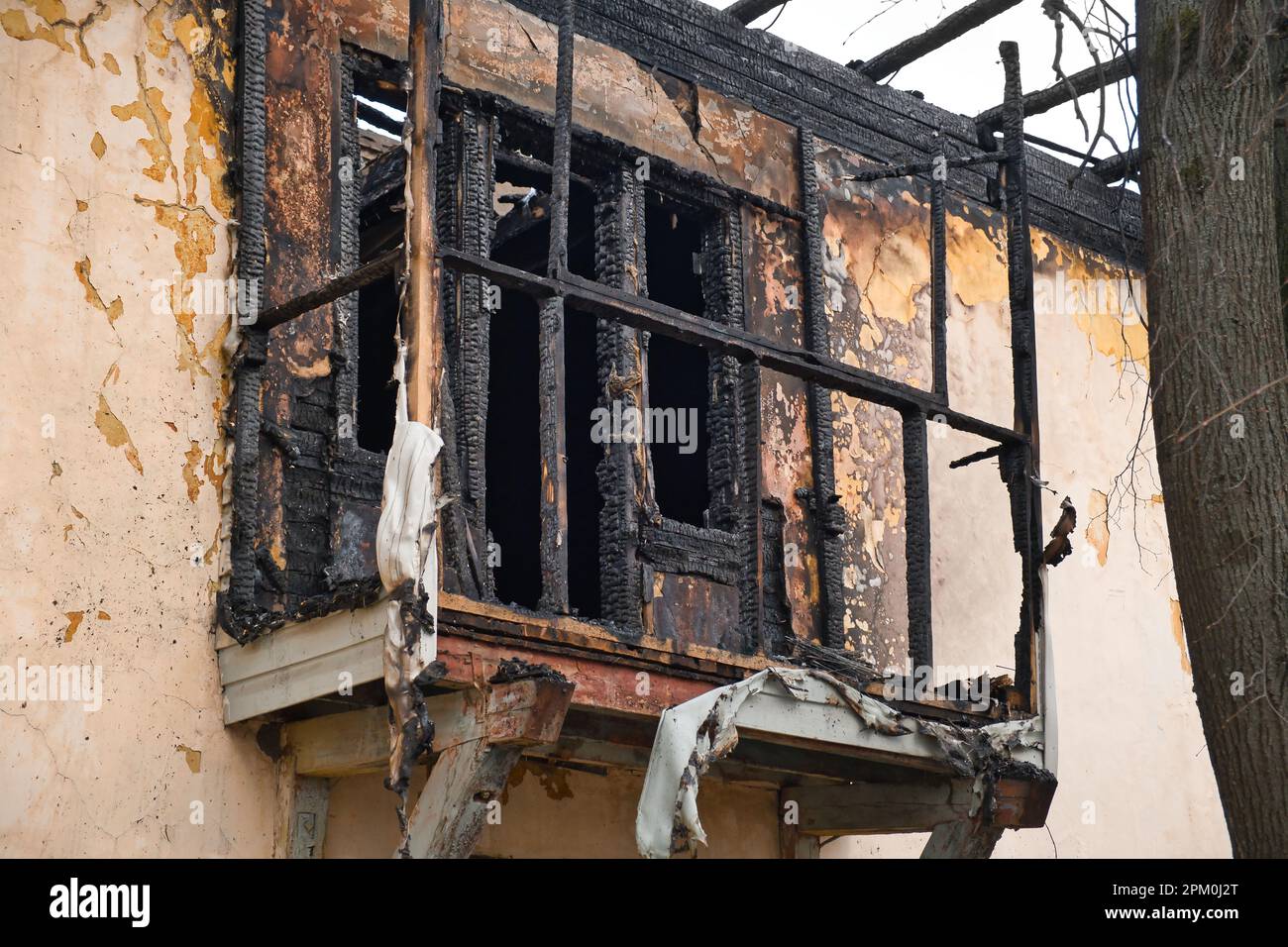 Fassade eines alten Hauses nach einem Brand. Balkon eines verbrannten Wohngebäudes. Außenansicht des zerstörten Hauses. Stockfoto