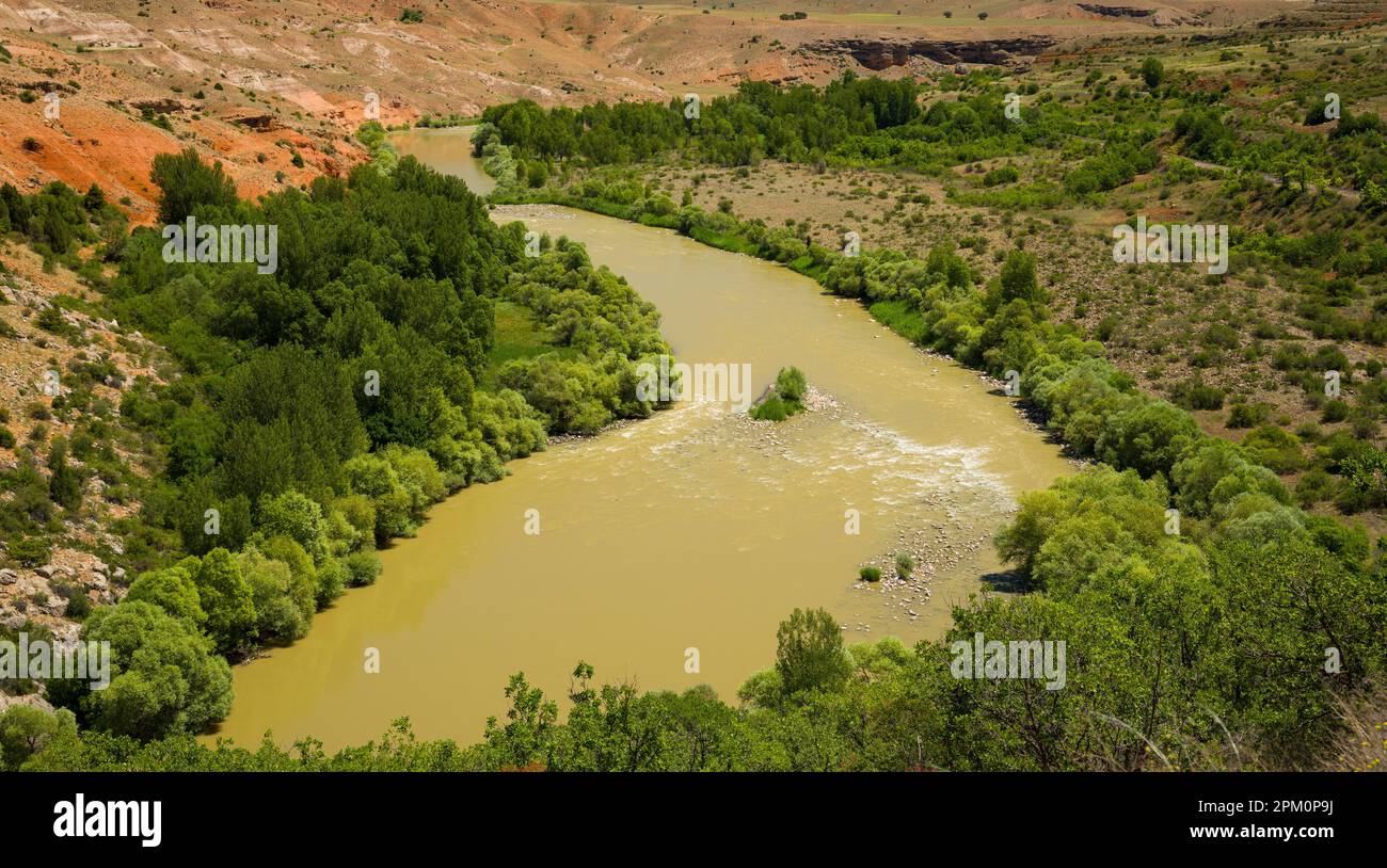 Der Fluss im Tal. Verschwommener fließender Fluss in trockener Klimazone. Farbenfroher Naturhintergrund Stockfoto