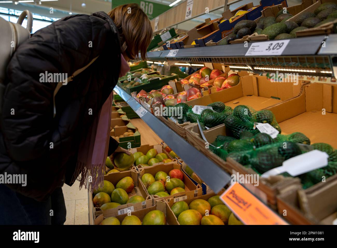 Porto, Portugal - 01.04.2023: Kunde wählt Mangos in der Obstabteilung des Supermarkts Lidl in Porto, Portugal Stockfoto