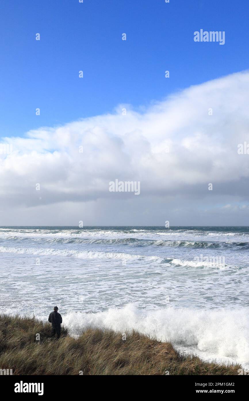 Ein Mann blickt über stürmische Meere und Gezeiten an der pazifikküste im Nordwesten von Oregon. Stockfoto