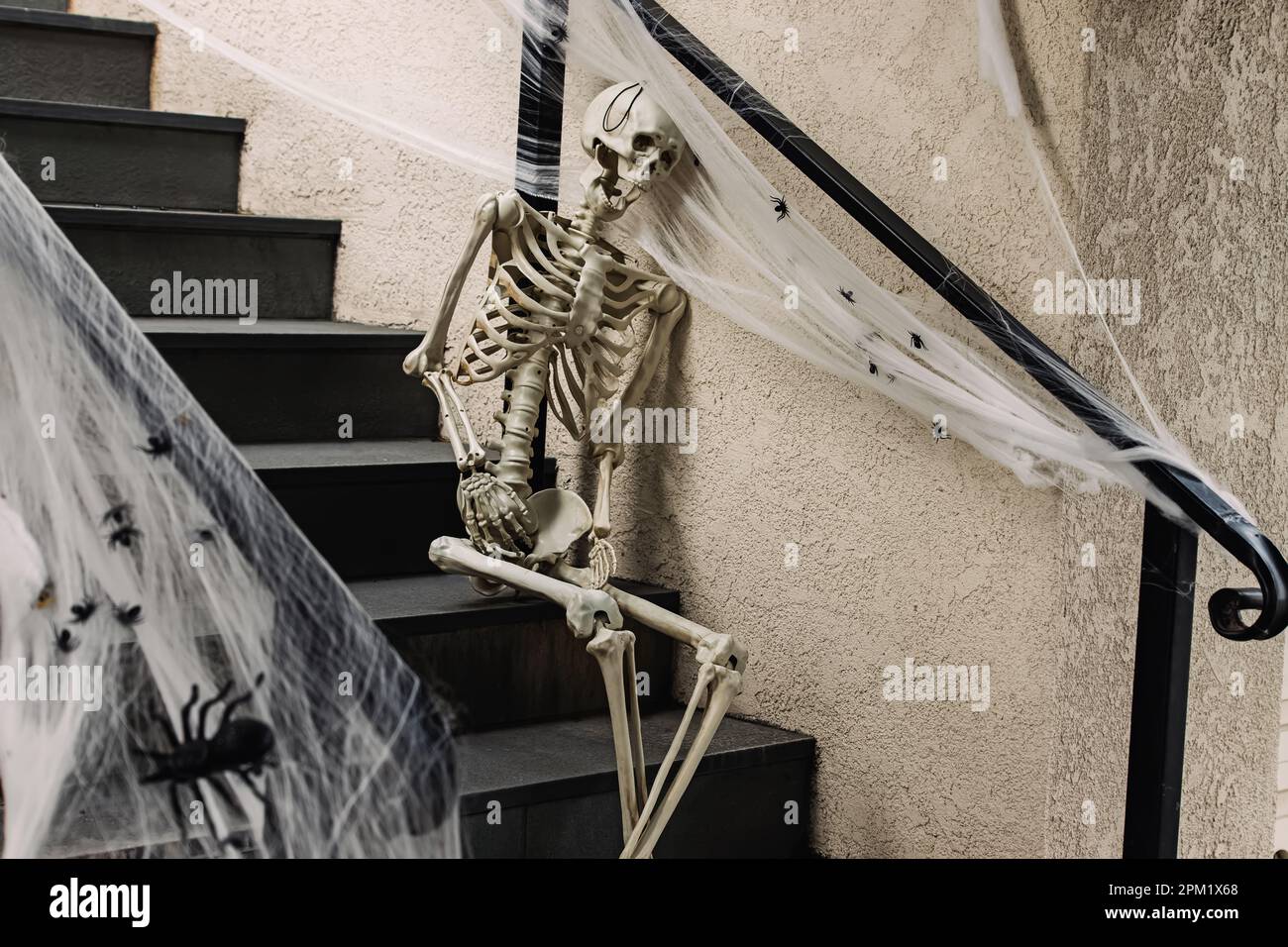 Unheimliche Halloween-Dekoration vor dem Haus, Skeleton sitzt auf der Treppe Stockfoto