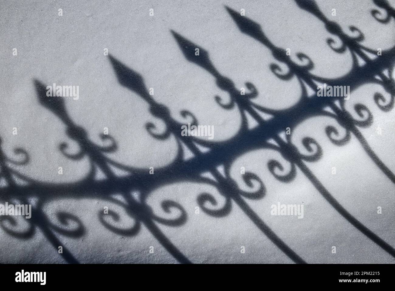 Gusseiserner Zaunschatten auf dem Schnee Stockfoto