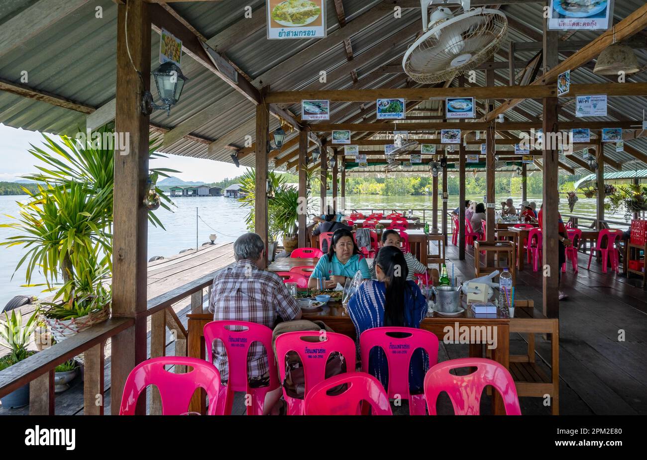 Gäste genießen eine gute Mahlzeit in einem Restaurant am Wasser, Sam Chong Seafood am Bang Lam River. Kalai, Thailand. Stockfoto