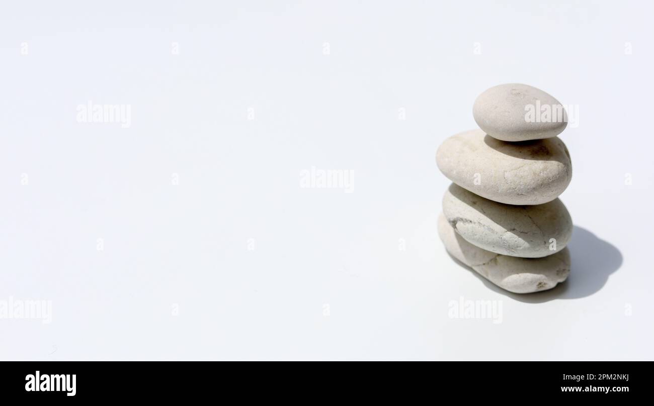 Gestapelte Kieselsteine auf isoliertem weißem Hintergrund - Zen und Spa Stockfoto
