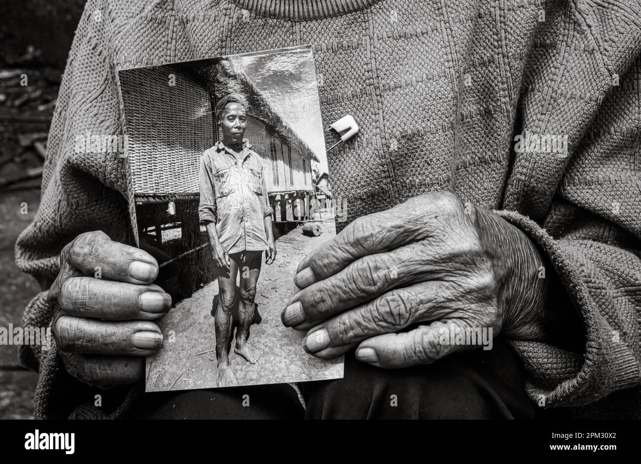 Die Hände einer älteren Witwe aus der ethnischen Minderheit Jerais in den zentralen Highlands Vietnams besitzen ein Foto ihres verstorbenen Mannes, des Dorfes C. Stockfoto