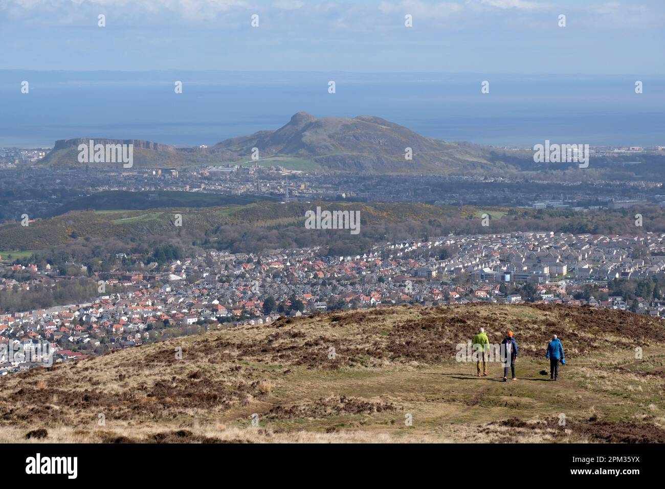 Edinburgh, Schottland, Großbritannien. 11. April 2023 Wanderer genießen heute Morgen das gute Wetter auf den verschiedenen Wegen und Pfaden rund um den Pentland Hills Regional Park. Blick über die Dächer von Edinburgh South Richtung Arthurs Seat. Kredit: Craig Brown/Alamy Live News Stockfoto