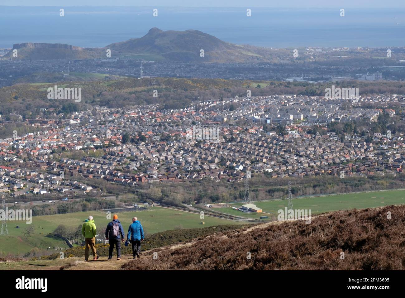 Edinburgh, Schottland, Großbritannien. 11. April 2023 Wanderer genießen heute Morgen das gute Wetter auf den verschiedenen Wegen und Pfaden rund um den Pentland Hills Regional Park. Blick über die Dächer von Edinburgh South Richtung Arthurs Seat. Kredit: Craig Brown/Alamy Live News Stockfoto