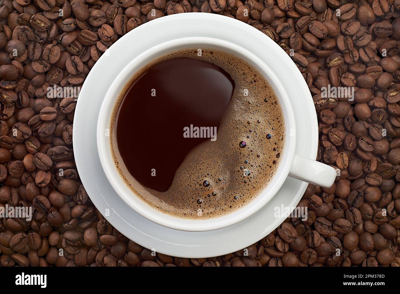 Tasse Kaffee auf geröstetem Bohnen-Hintergrund Stockfoto