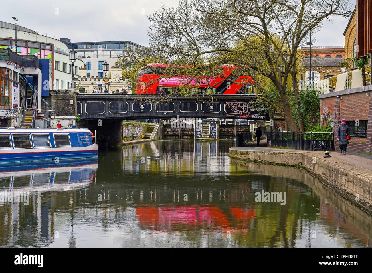 Camden Town, London, Vereinigtes Königreich: Regents Canal in der Nähe des Camden Market mit Blick auf Camden High Street und Camden Lock. Kanalboot, Schleppweg, Brücke und Bus. Stockfoto