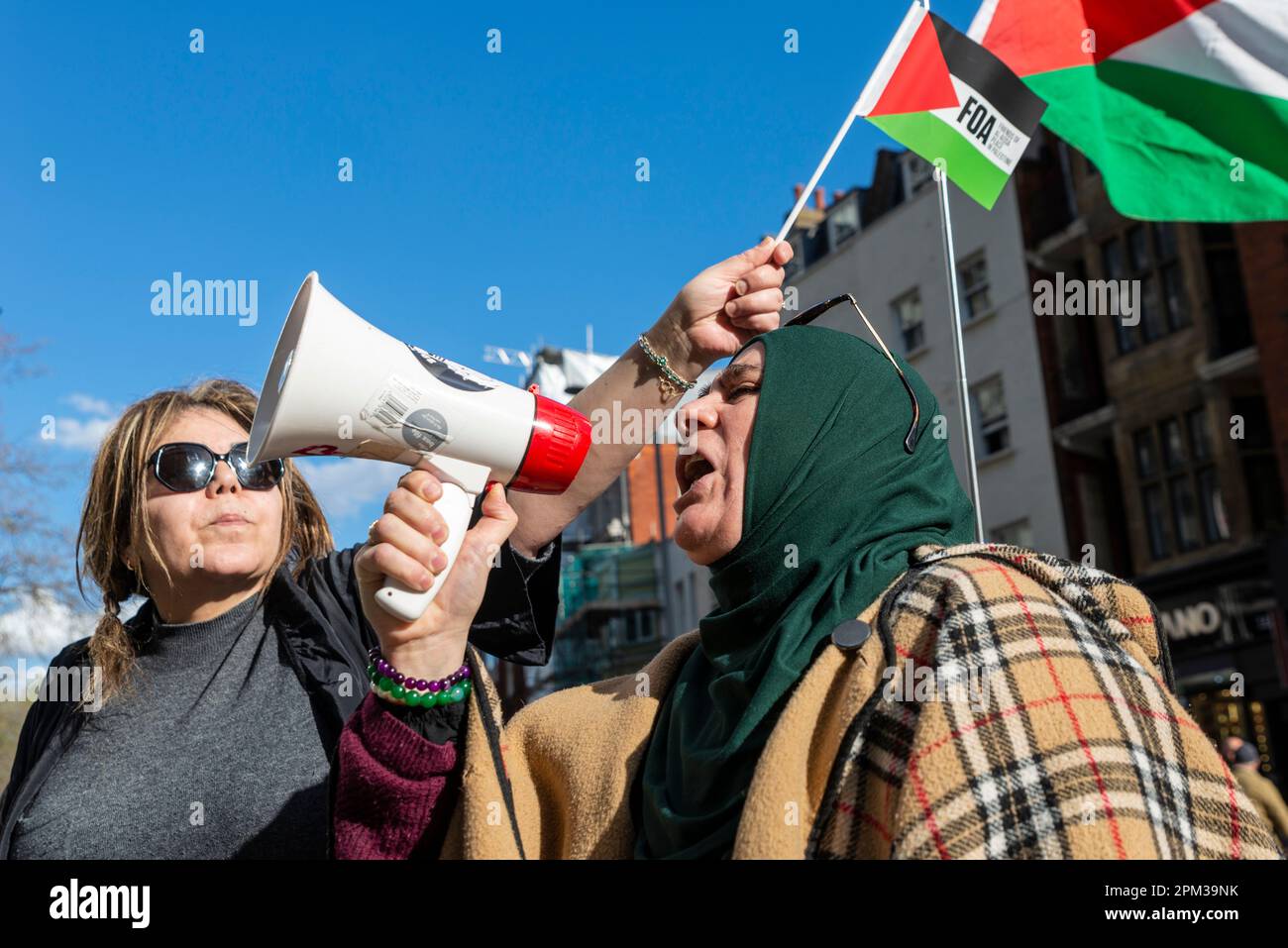 Protest von Anhängern Palästinas außerhalb der israelischen Botschaft in Kensington, London, Großbritannien, und Protest gegen die Handlungen Israels. Weiblicher Gesang Stockfoto