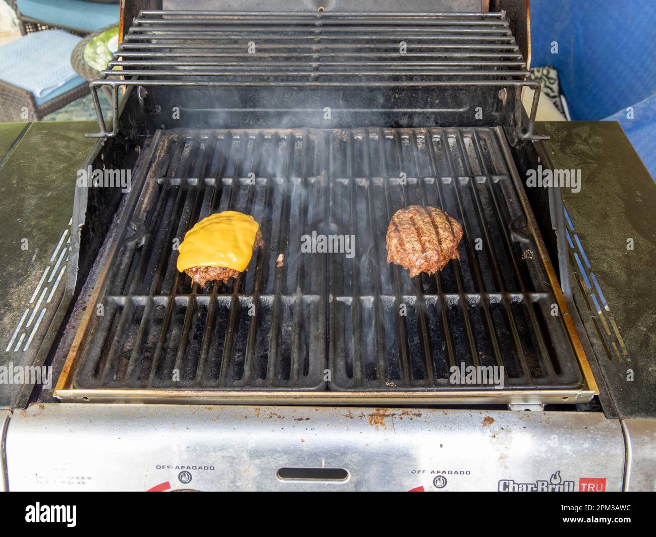 Hamburger und Cheeseburger Grillen auf einem Gasgrill im Freien in Montgomery Alabama, USA. Stockfoto
