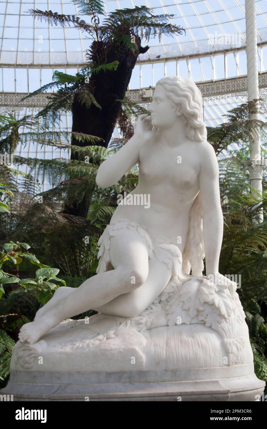 Skulptur von Eve vom römischen Bildhauer Scipione Tadolini, die um 1875 in Marmor im Kibble Palace Gewächshaus in den Glasgow Botantic Gardens geschnitzt wurde, Stockfoto