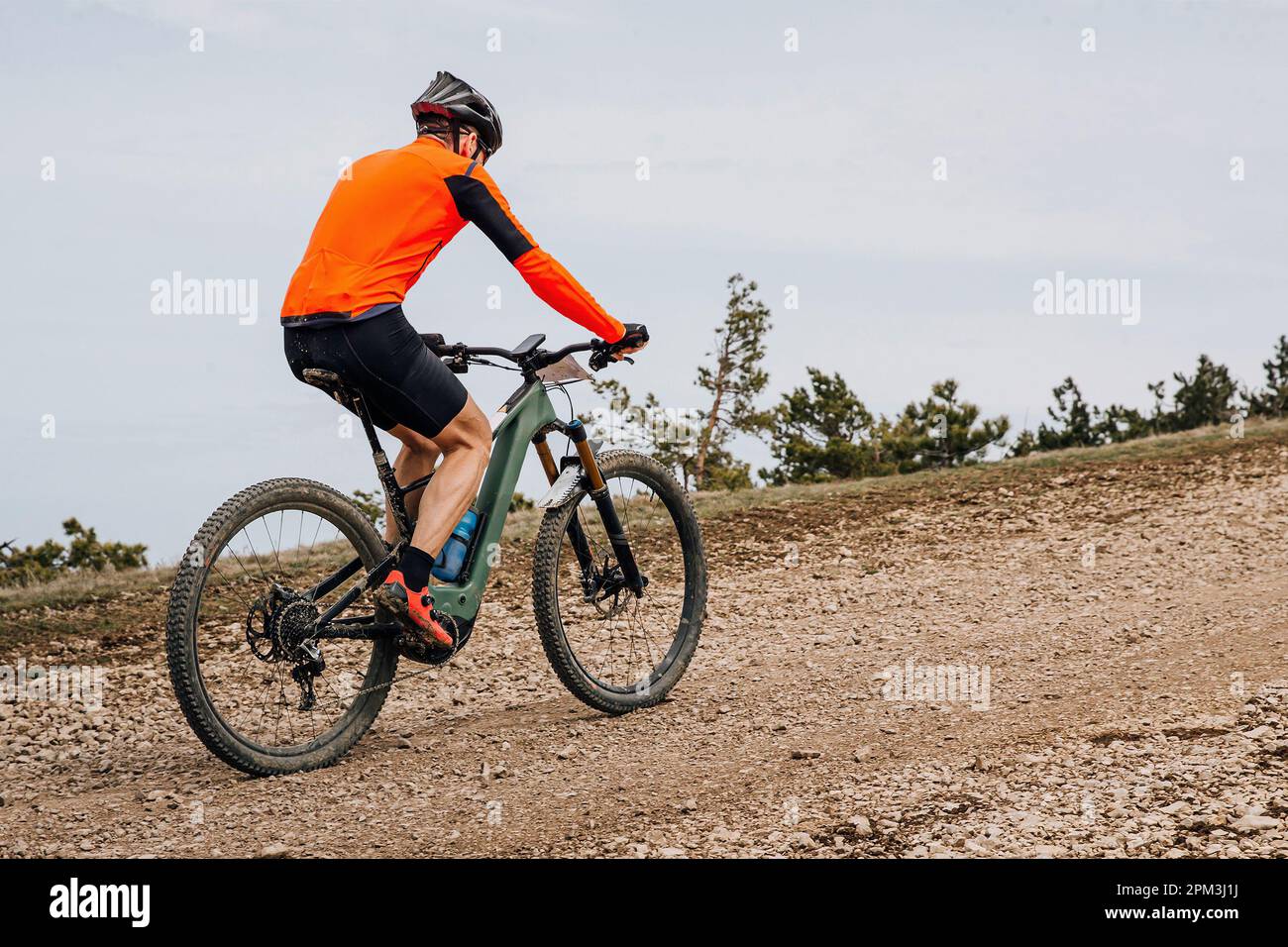 Männlicher Radfahrer, der Mountainbike bergauf fährt, Langlauftour, Radtour auf Schotterstraße Stockfoto