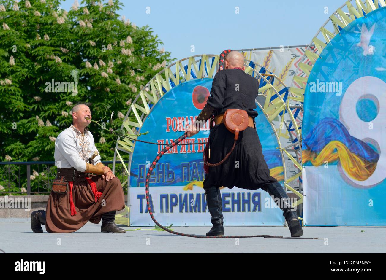 Männer in ukrainischen traditionellen kosakenkostümen tanzen Peitschentanz während der Tagung zum Gedenktag, Stadtpark. 8. Mai 2019. Kiew, Großbritannien Stockfoto