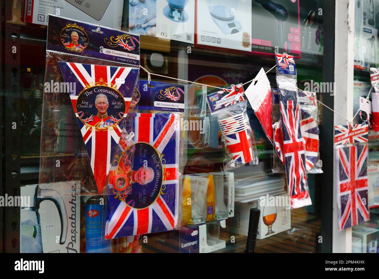 Tonbridge, Kent, 11. April 2023. Billige Union-Jack-Flaggen, Fähnchen und andere Erinnerungsstücke zur bevorstehenden Krönung von König Karl III. Zum Verkauf vor einem Eisenwarenladen. König Karl III. Wird am Samstag, den 6. Mai 2023 in Westminster Abbey in London gekrönt. Stockfoto