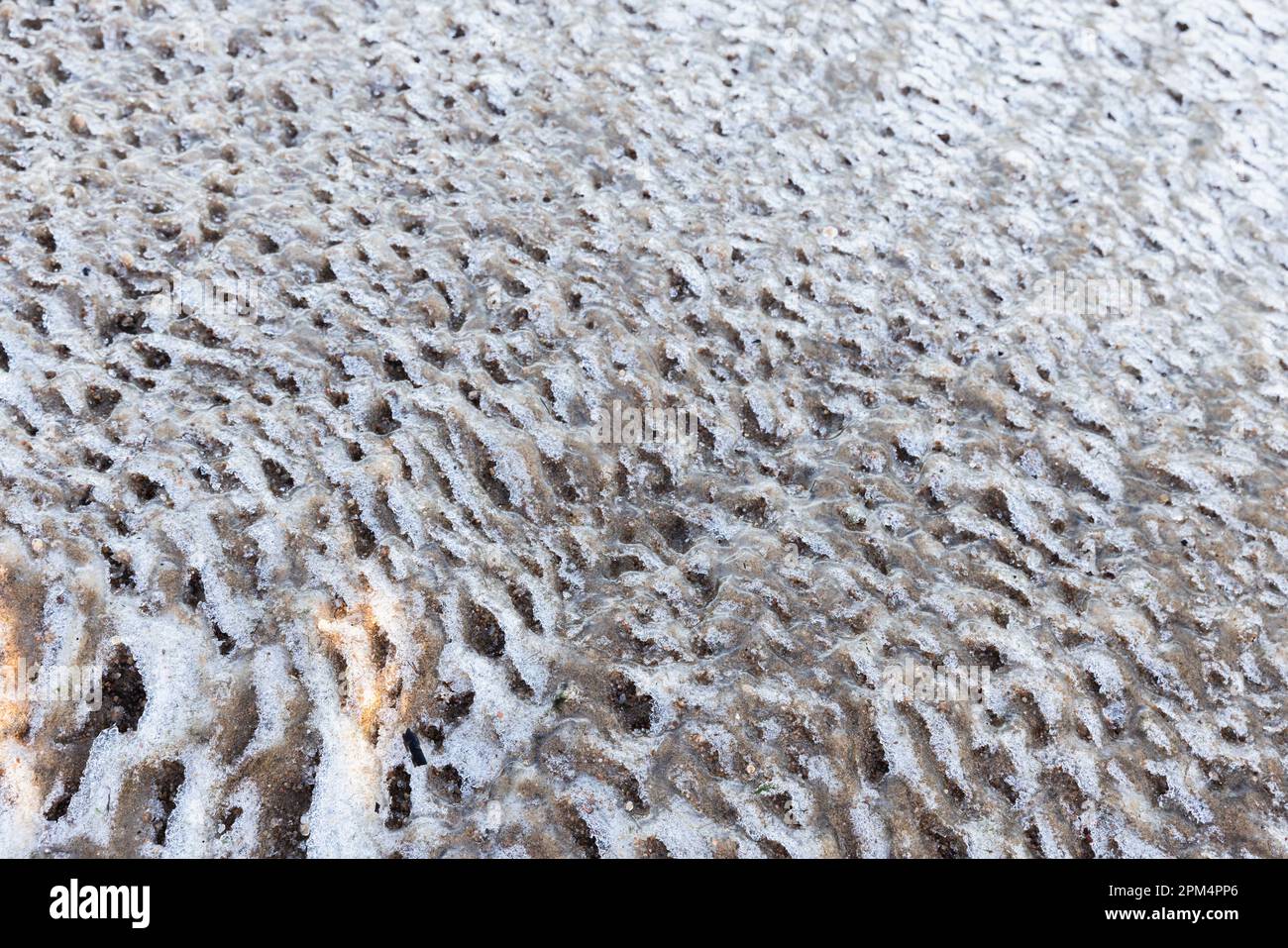Schmelzende Eisschollen Oberfläche mit Sand, natürliche winterliche Fotostruktur Stockfoto