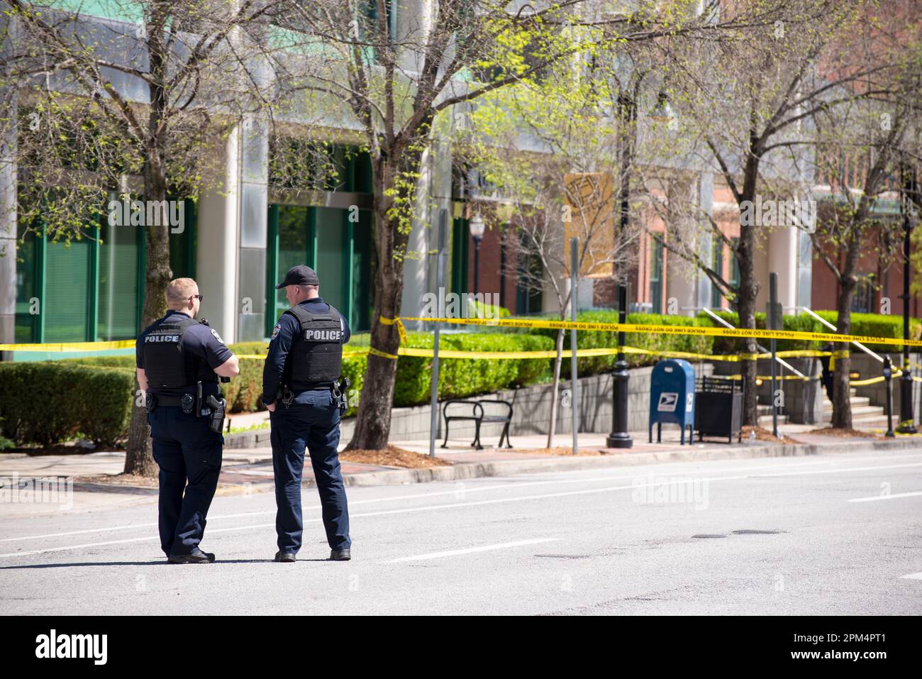 Louisville, Kentucky, USA. 10. April 2023. Zwei Polizisten des Louisville Metro Police Departments stehen vor der Messe auf der Straße Wache Stockfoto