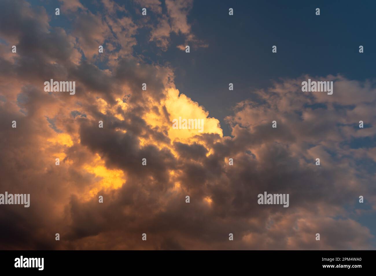 Perfekter Hintergrund helle goldorange Wolken, die von Sonnenlicht beleuchtet werden. Sommerabend mit hellem Himmel, der Ihre Fotos überlagert Stockfoto