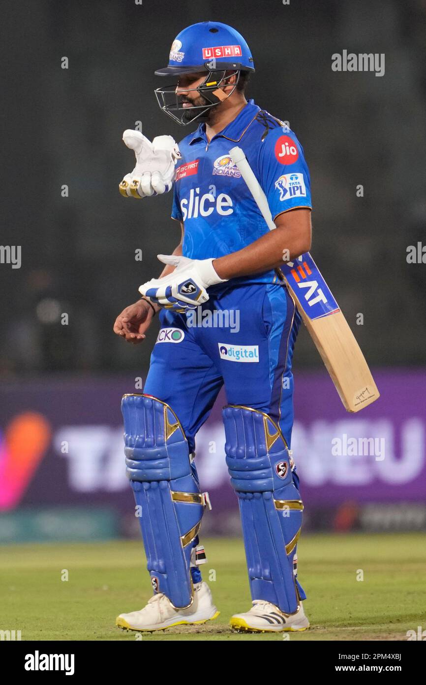 Mumbai Indians' captain Rohit Sharma throws his glove up as he walks