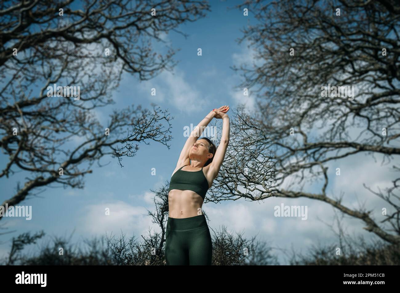 Sportliche Frau, die im Park Stretching-Übungen macht Stockfoto