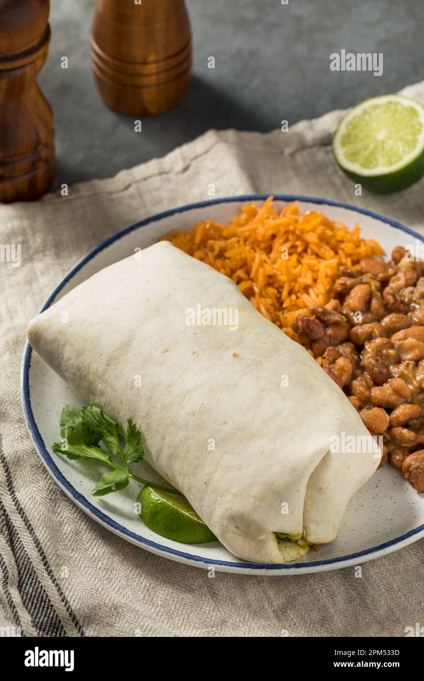 Hausgemachter mexikanischer Cheesy Steak Burrito mit Guacamole und Salsa Stockfoto