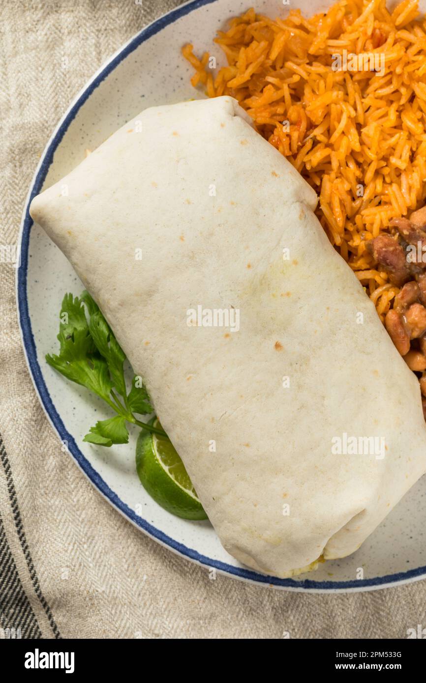 Hausgemachter mexikanischer Cheesy Steak Burrito mit Guacamole und Salsa Stockfoto