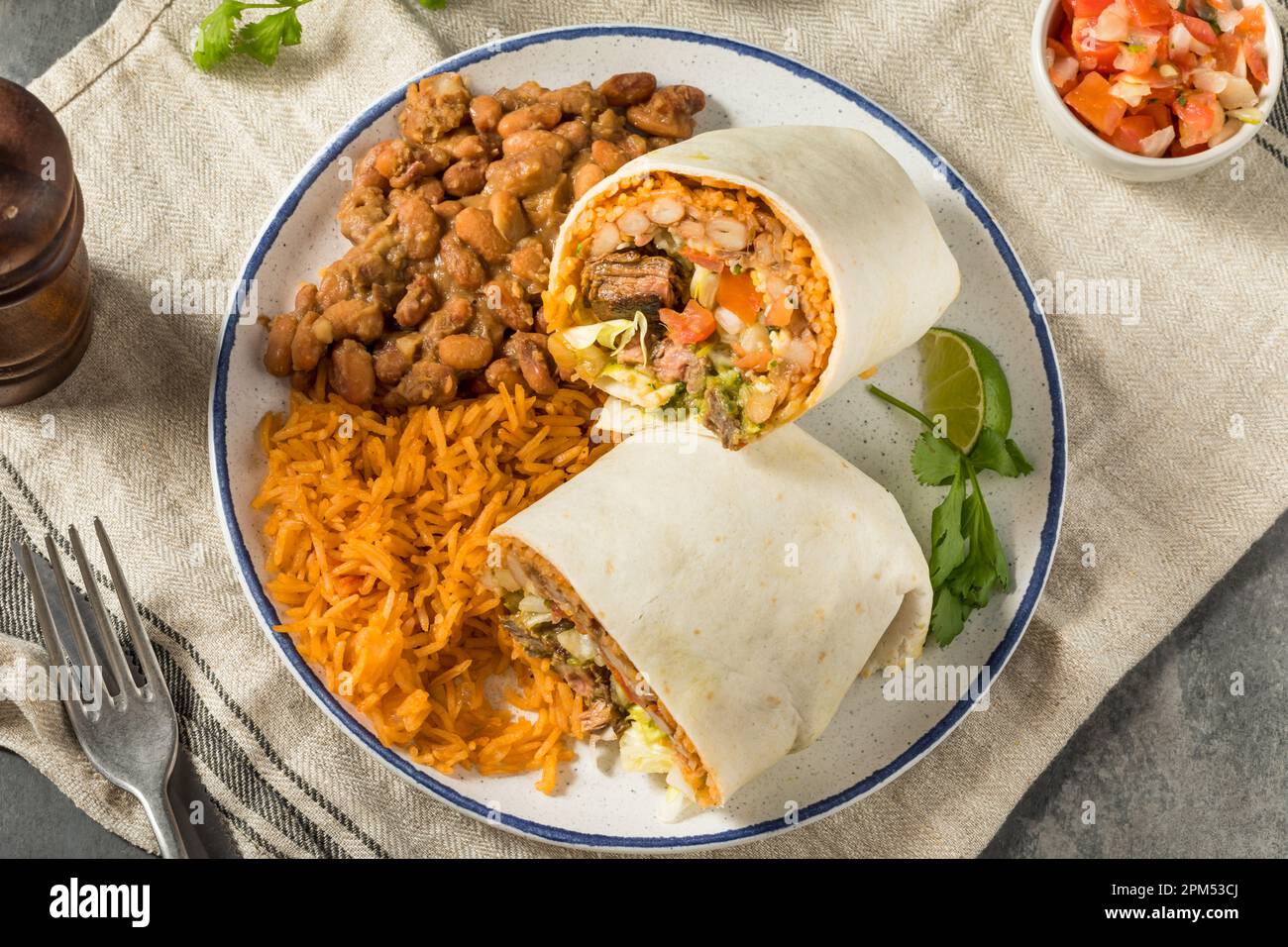 Hausgemachter mexikanischer Cheesy Steak Burrito mit Guacamole und Salsa Stockfoto