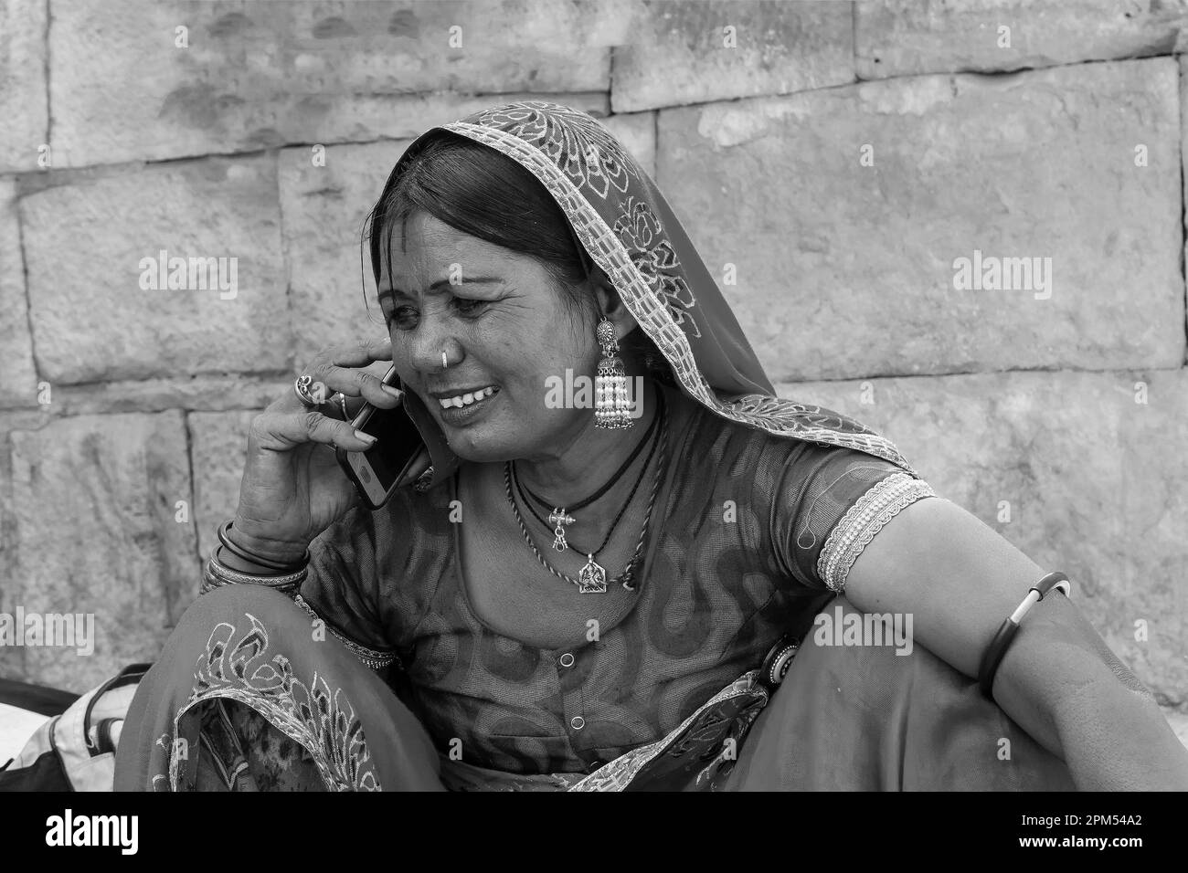 Jaisalmer, Rajasthan, Indien - 13. Oktober 2019 : Rajasthani Frau lächelnd, während sie im Mobiltelefon auf dem Marktplatz im Jaisalmer Fort sprach. Stockfoto