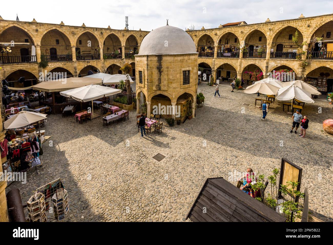 Innenhof Büyük Han, Great Inn, der größte Caravanserai in Zypern. Erbaut auf Befehl des ersten Herrschers der Osmanen in Zypern, Muzaffer Pascha, im Jahr 1572. Im Innenhof gibt es eine kleine Moschee mit einem Kuppeldach und einem Brunnen für Abwässer vor dem Gebet. Das Gebäude gilt als eines der schönsten Gebäude Zyperns und befindet sich im nördlichen zyprischen Teil der geteilten Stadt Nikosia, Zypern Stockfoto