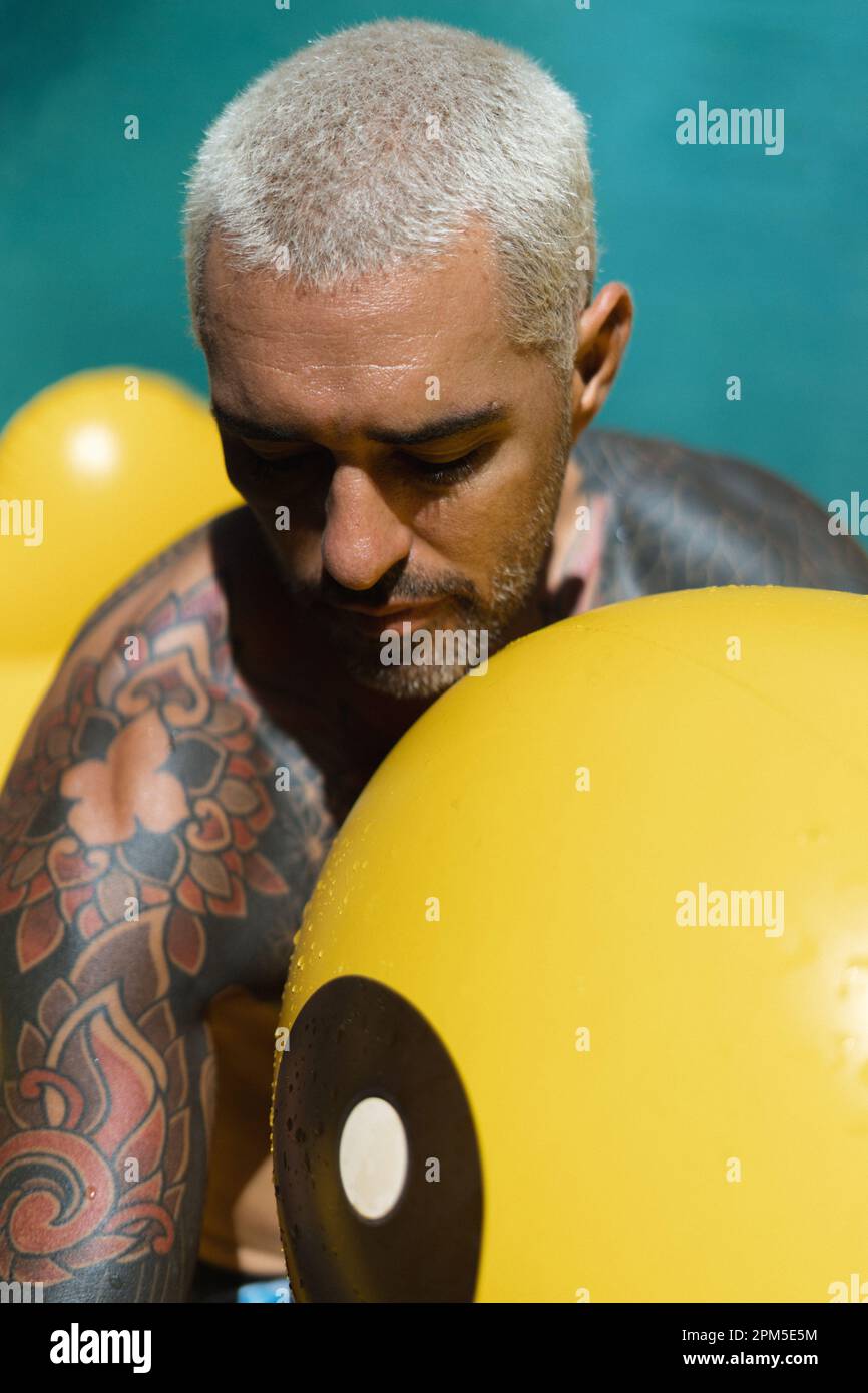 Junger, stilvoller tätowierter spanier im Pool. Stockfoto