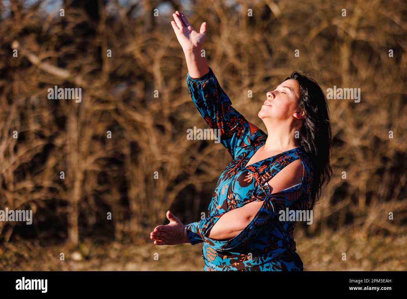 Eine Frau mit erhobenen Armen tanzt draußen Flamenco mit Leidenschaft Stockfoto