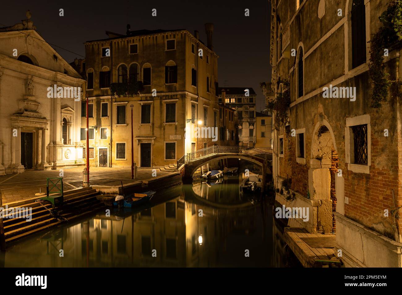 Blick auf den Kanal von Venedig bei Nacht mit Brücke Stockfoto