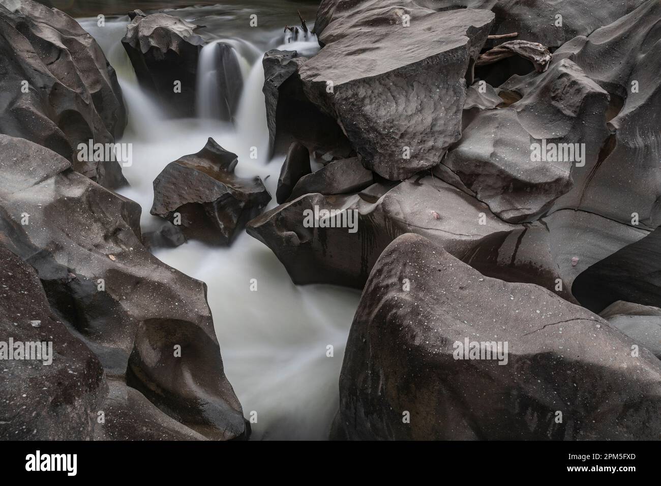 Fluss schneidet durch glatte brasilianische Felsformation Stockfoto