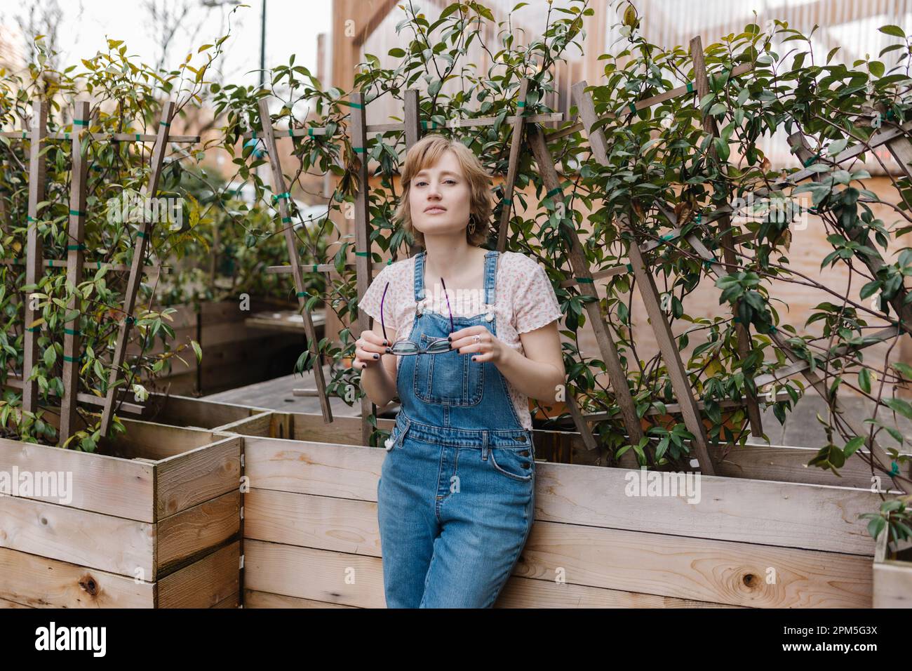 Eine rücksichtsvolle Frau, die im Innenhof eine Sonnenbrille auszieht Stockfoto