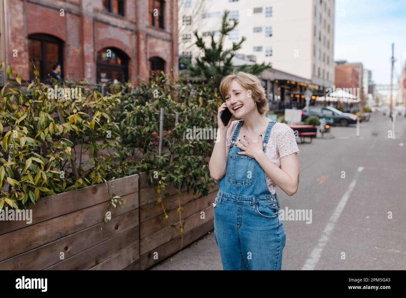 Eine glückliche Frau, die telefoniert und in die Stadt geht Stockfoto