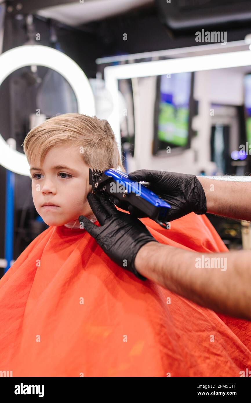 Ein 6-jähriges weißes Kind, das sich im Friseursalon in Portland die Haare schneiden lässt Stockfoto
