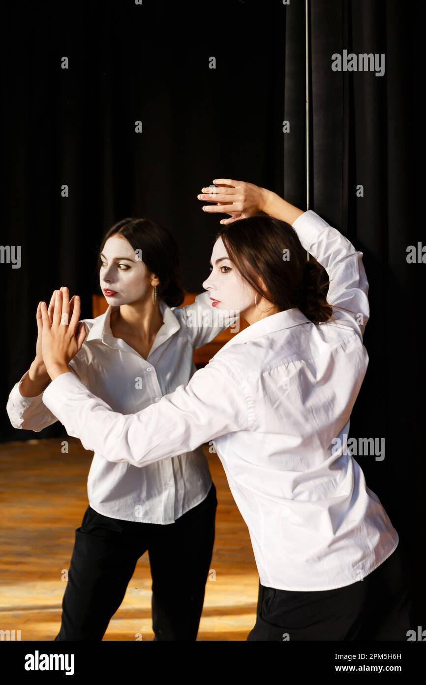 Junge Schauspielerin in einem Kostüm mit weißer Make-up im Probetheater Stockfoto