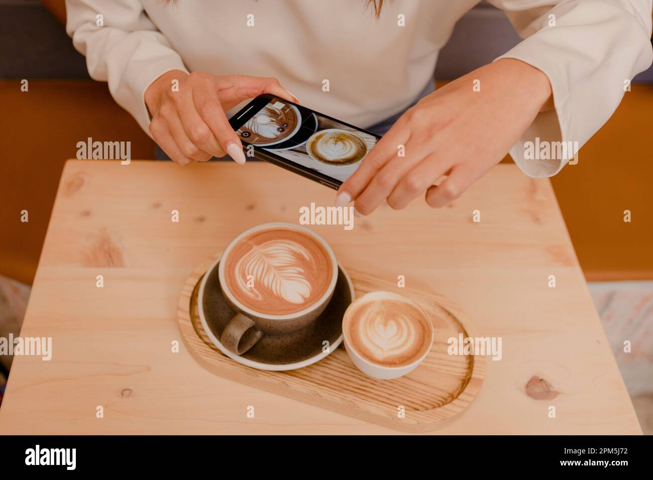 Frauen machen ein Foto vom Kaffee mit dem Smartphone Stockfoto