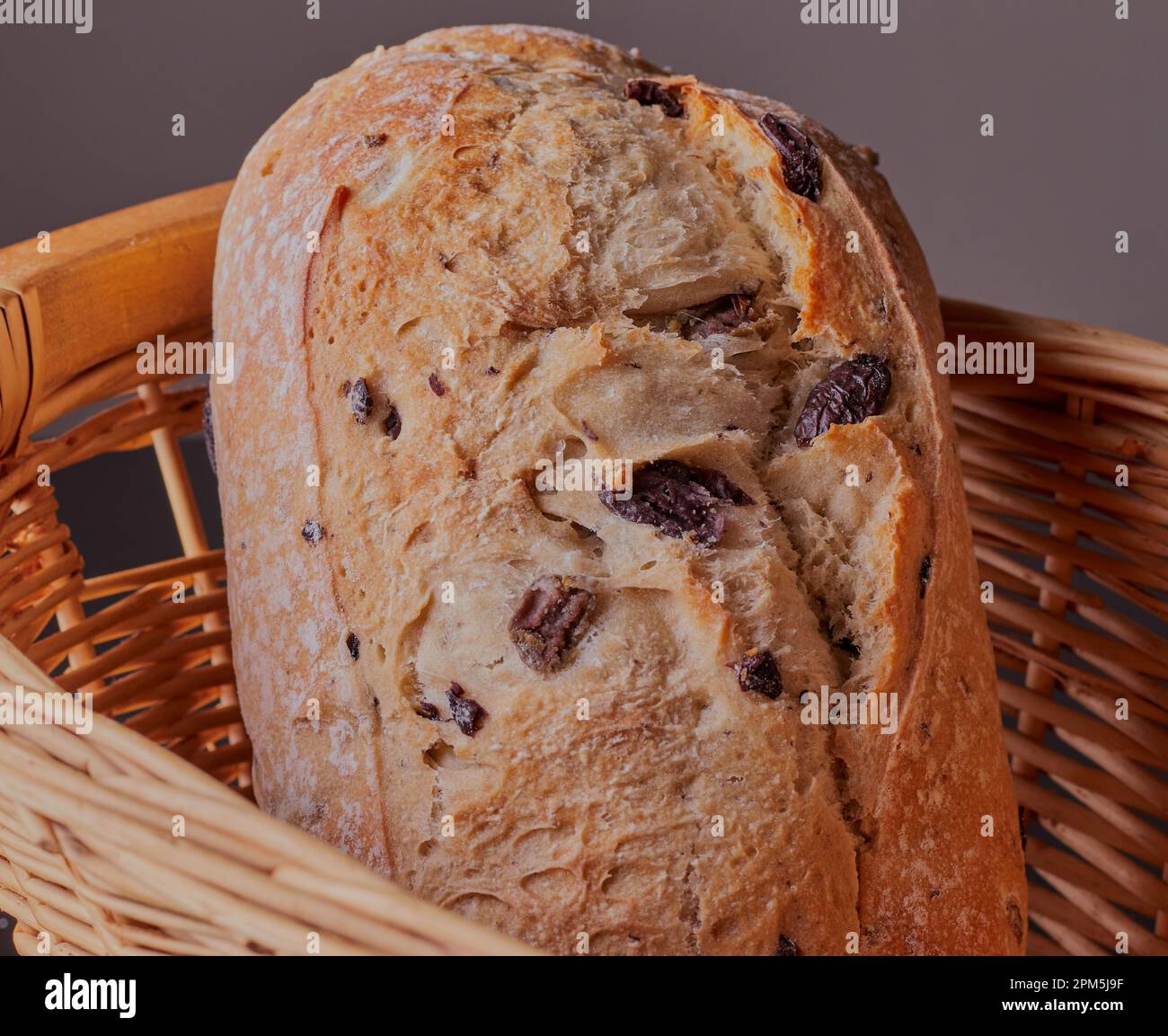 Frisch gebackener Brotlaib aus Cashewnüssen, der im Korb ruht. Stockfoto