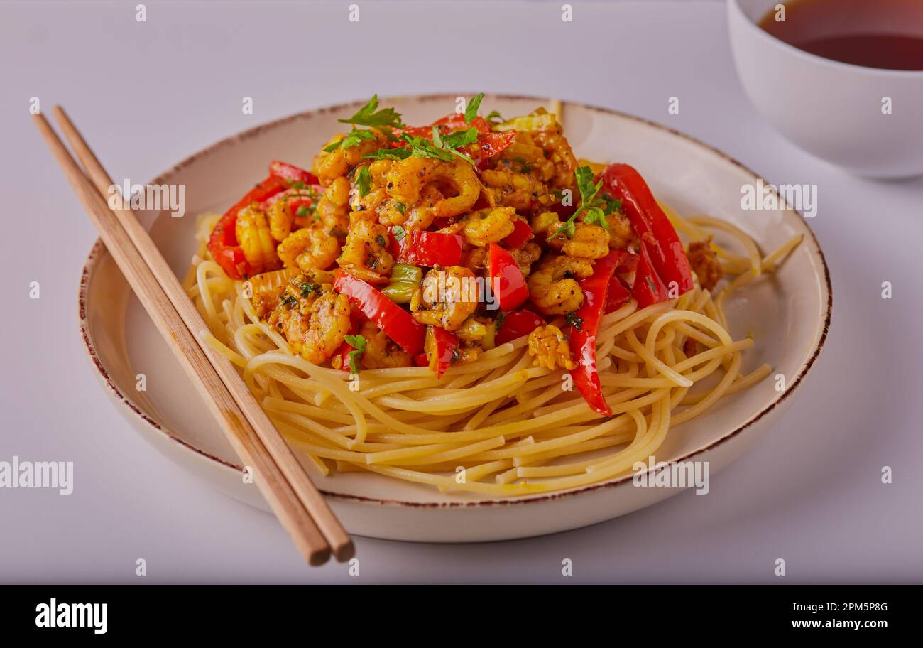 Garnelen-Curry mit Nudeln und garniert mit Kräutern Stockfoto